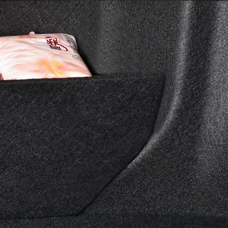 A pink packaged item stored in a black felt car seat organizer pocket.