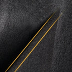 Close-up of black textured car floor mat with elegant gold stitching detail.