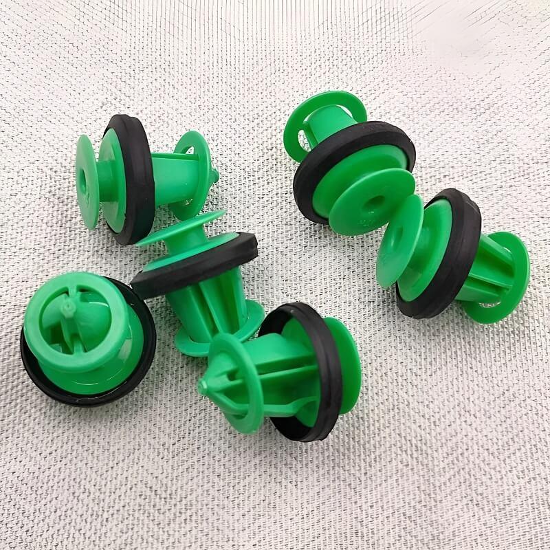 Set of green plastic and black rubber automotive sprinkler nozzles for vehicle cleaning.