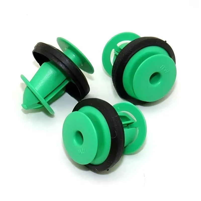 Three green plastic automotive trim clips with black rubber gaskets for secure fastening.