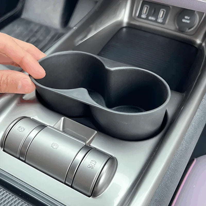 Matte black dual-compartment car cup holder accessory for organized vehicle storage.