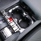 Close-up of gray leather center console with dual cup holders and silver metallic accents.