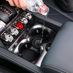 Water spilling into a black car cup holder liner designed for spill protection.