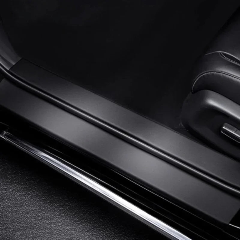 Black matte finish door sill protector with polished chrome trim for car interior protection.
