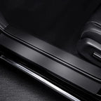 Black matte finish door sill protector with polished chrome trim for car interior protection.