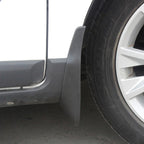Close-up of a durable matte black plastic mud guard installed behind a car tire.