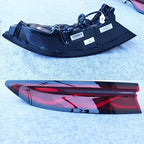 Sleek black and red aftermarket car tail light assembly with a glossy finish.
