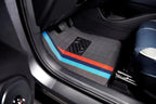 Grey fabric car floor mat featuring distinctive red and blue racing stripes.