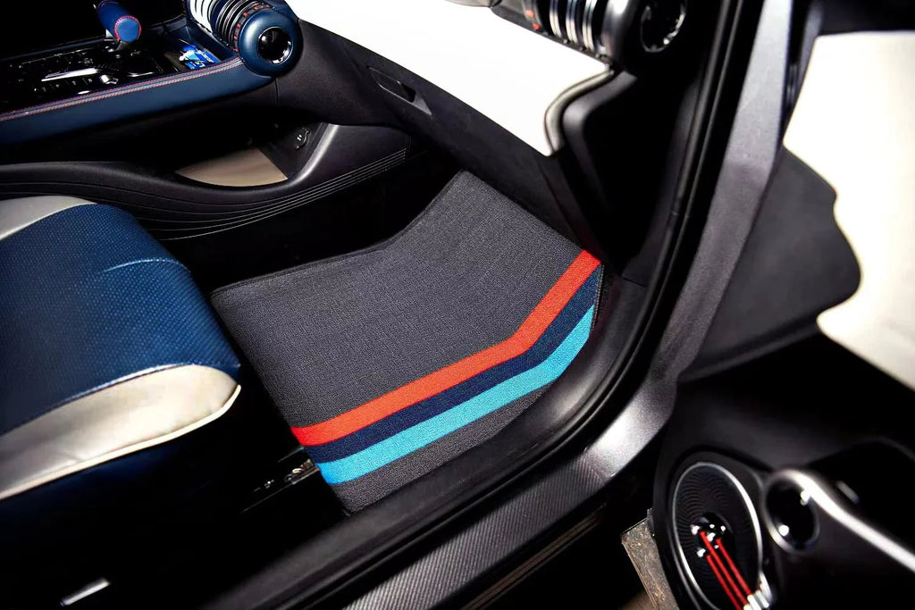 Grey fabric car floor mat with distinctive red and blue racing stripes for BYD interior protection.