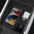 Black textured center console organizer tray for BYD holding a smartphone and charger.
