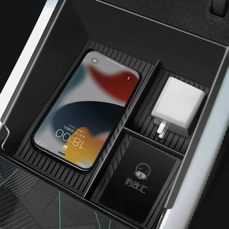 Black textured center console organizer tray for BYD holding a smartphone and charger.