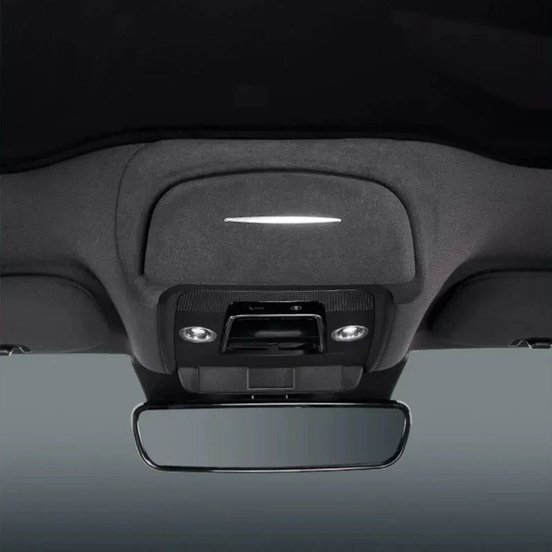 Grey fabric car interior ceiling featuring a sleek LED light strip and rearview mirror.