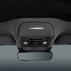 Grey fabric car interior ceiling featuring a sleek LED light strip and rearview mirror.