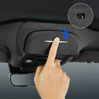 Black fabric car sun visor with a silver handle being pulled down for protection.