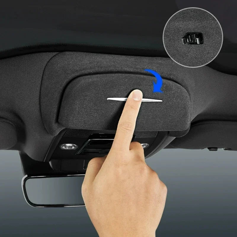 Black fabric car sun visor with a silver handle being pulled down for protection.