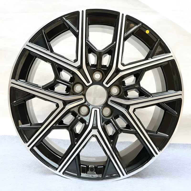 Black and silver dual-tone alloy car rim with a multi-spoke geometric design.