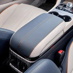 Premium blue and white leather center console armrest with orange contrast stitching.