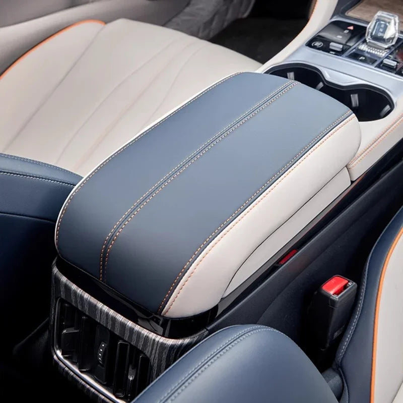 Premium blue and white leather center console armrest with orange contrast stitching.