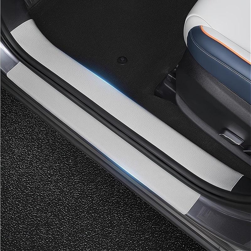 Silver protective car door sill plates with blue ambient lighting for BYD interior.
