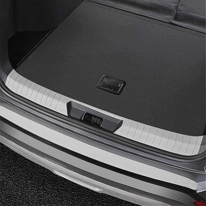 Silver textured metal rear bumper protector installed on a black car trunk sill