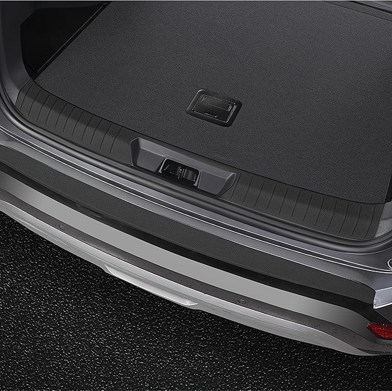 Black textured carbon fiber rear bumper protector for car trunk protection.