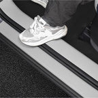 Close-up of a grey car door sill protector with black rubber trim edges.
