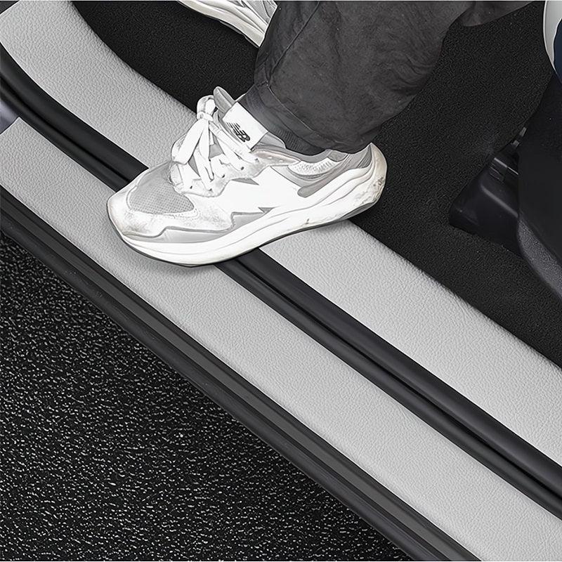 Close-up of a grey car door sill protector with black rubber trim edges.