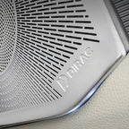 Silver metallic Dirac speaker grille with precision-cut ventilation patterns on car interior.