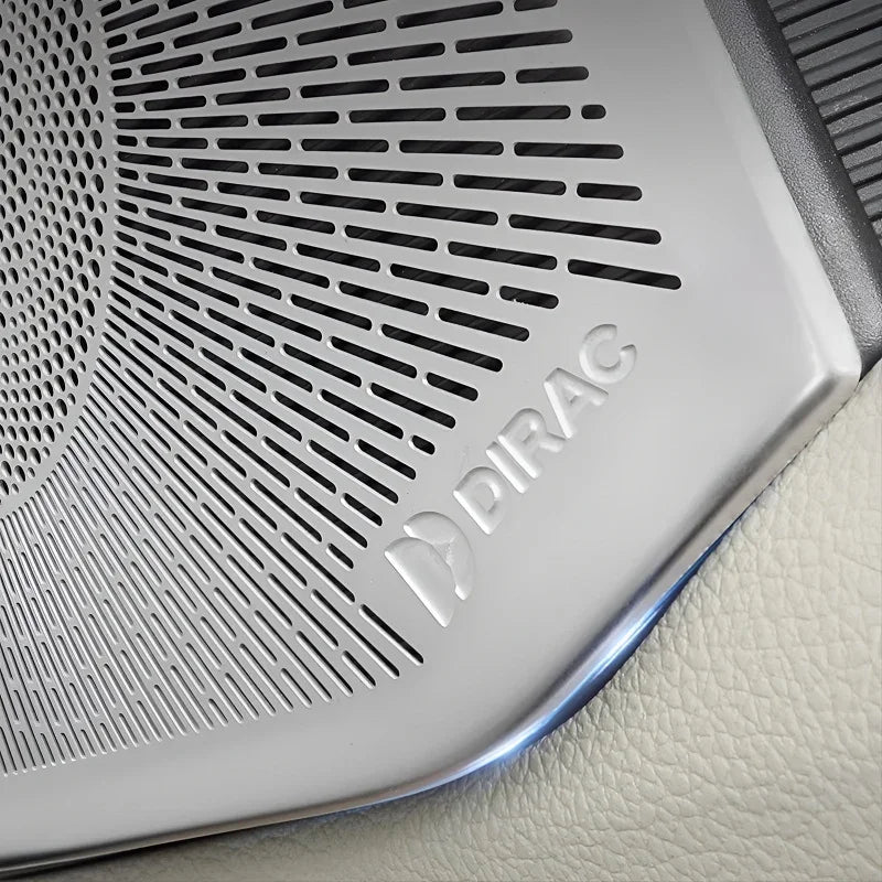 Silver metallic Dirac speaker grille with precision-cut ventilation patterns on car interior.