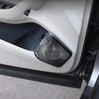 Premium black Dirac car door speaker with a textured metallic mesh grille on a white interior panel.