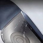 Close-up of a black metallic textured speaker grille with a premium silver patterned finish.