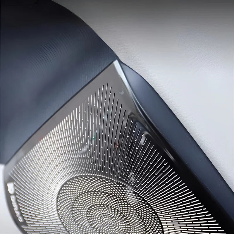Close-up of a black metallic textured speaker grille with a premium silver patterned finish.