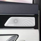 Silver Dirac premium speaker grille with a unique swirl pattern on a black car door panel.