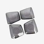 Set of four premium black metallic speaker grilles with a concentric circular pattern.