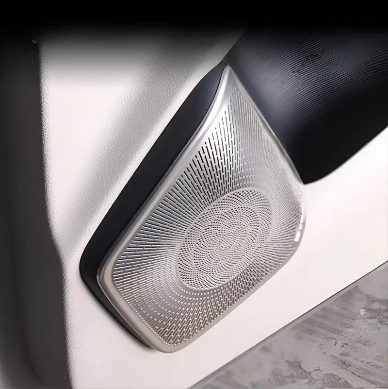 Silver brushed metal speaker grille cover for car door interior trim.