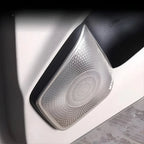Silver brushed metal speaker grille cover for car door interior trim.