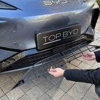Black matte mesh lower bumper grille protector being installed on a grey BYD vehicle.