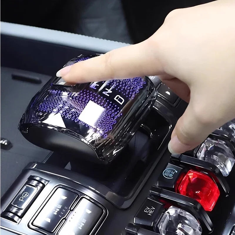 Hand pressing a glossy black crystal gear shift knob with purple LED lighting for BYD.