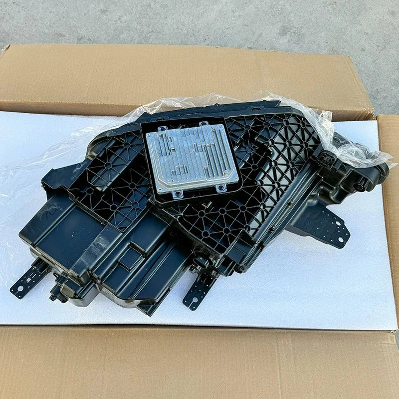 Black textured plastic automotive component with a silver metallic heat sink module.