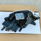 Black textured plastic automotive component with a silver metallic heat sink module.