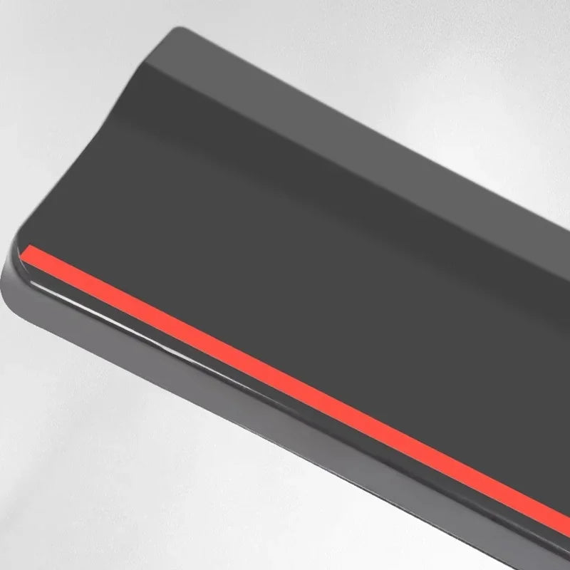 Close-up of a sleek matte black car accessory featuring a bold red accent stripe.