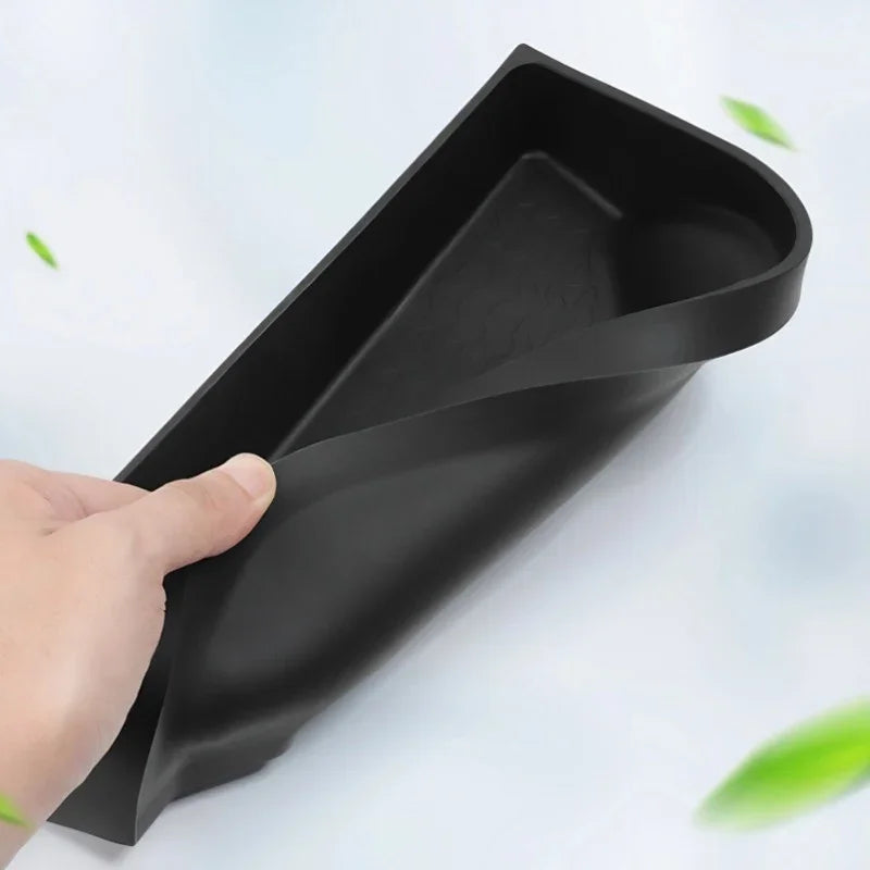 Flexible black TPE car floor mat being bent to show durable, waterproof material.