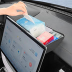 Black leather car dashboard organizer tray holding tissues and small essentials.
