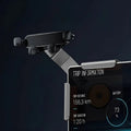 Black smartphone holder mounted on a sleek silver metal arm, positioned in front of a car dashboard screen.