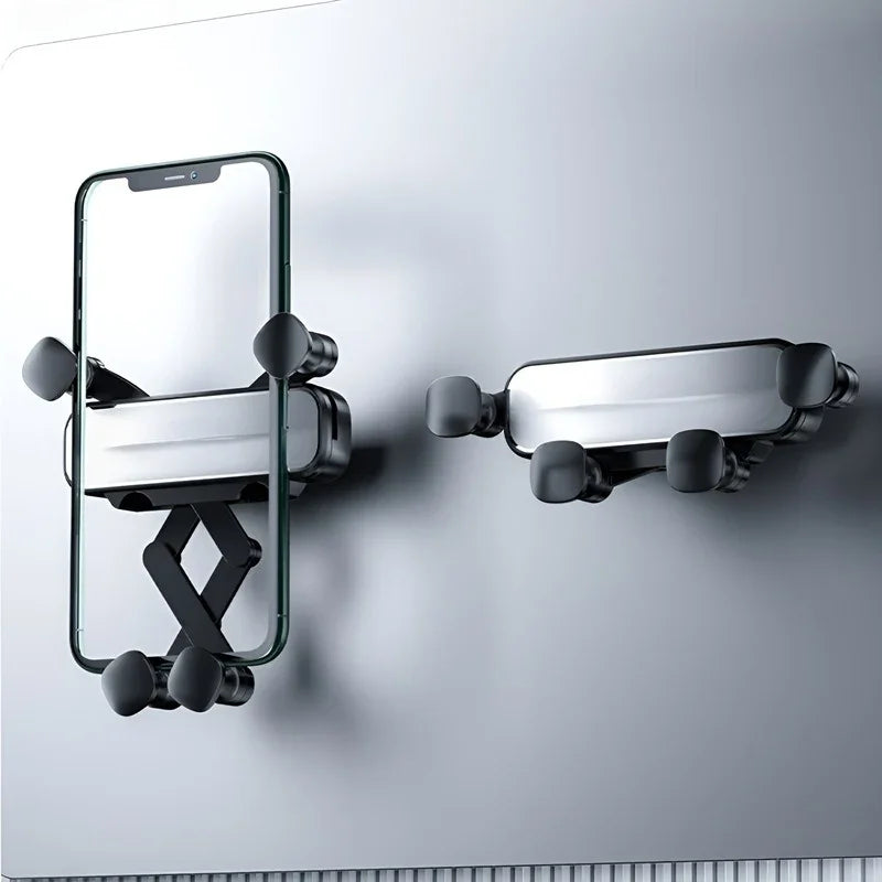 Black adjustable suction cup smartphone holder mounted on a smooth grey surface.