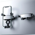 Black adjustable suction cup smartphone holder mounted on a smooth grey surface.