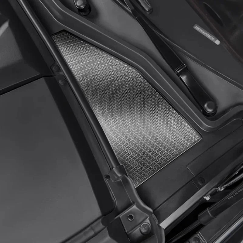 Close-up of a silver textured metal cargo liner installed in a black car trunk.