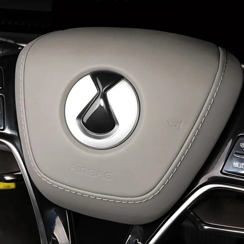 Grey leather steering wheel cover with white stitching and silver logo