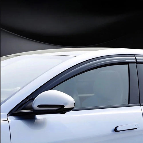 Sleek black tinted window deflectors installed on a white car for enhanced ventilation and style.