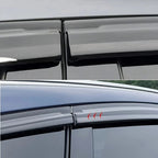Sleek black window deflectors made of durable matte material for premium car door protection.